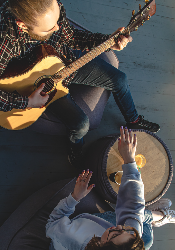 young-man-plays-guitar-girl-top-view 1